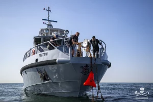 Personen ziehen Geisternetz aus dem Meer